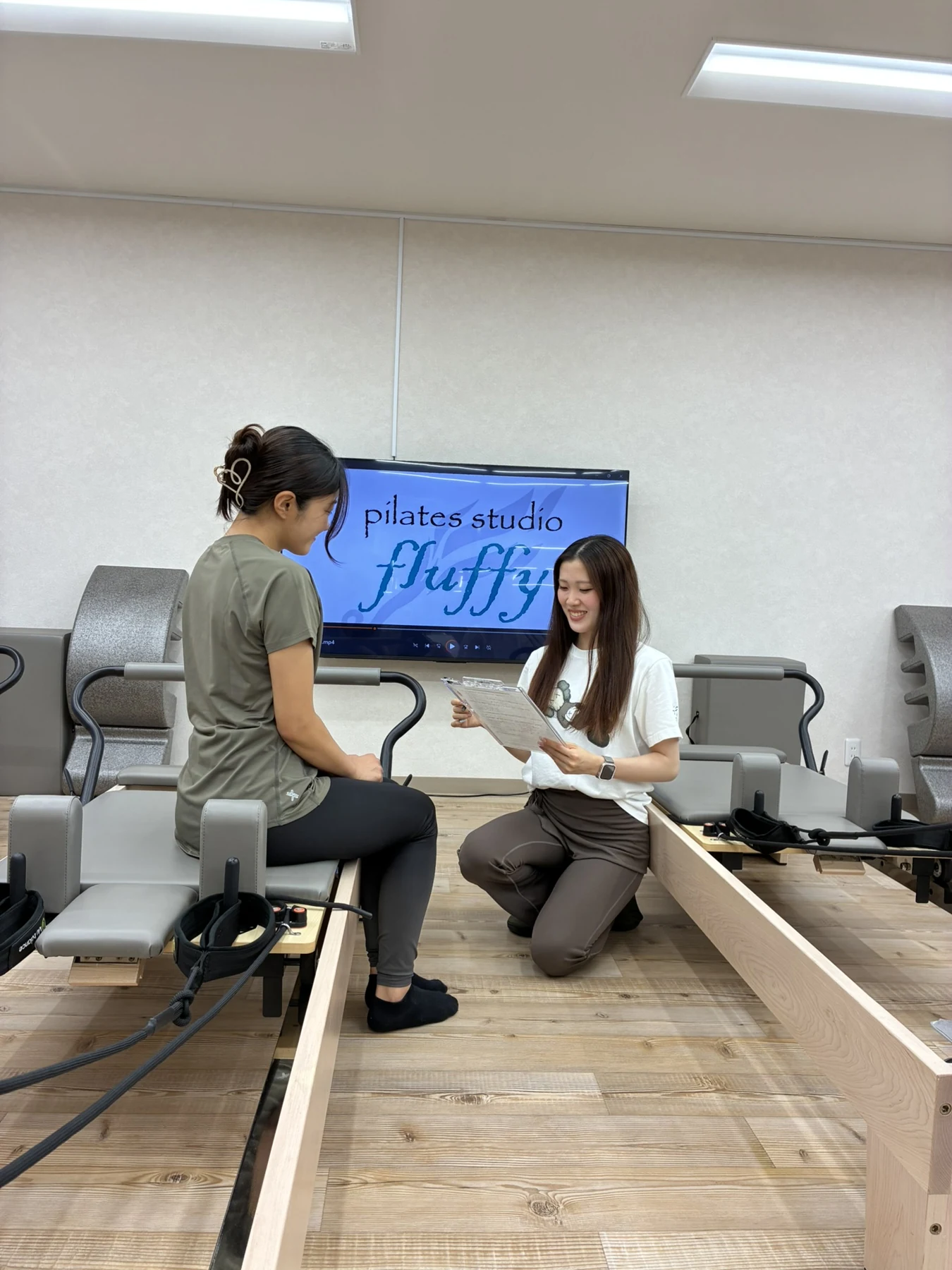 スタジオで、目線を合わせて笑顔で会話するインストラクターと女性